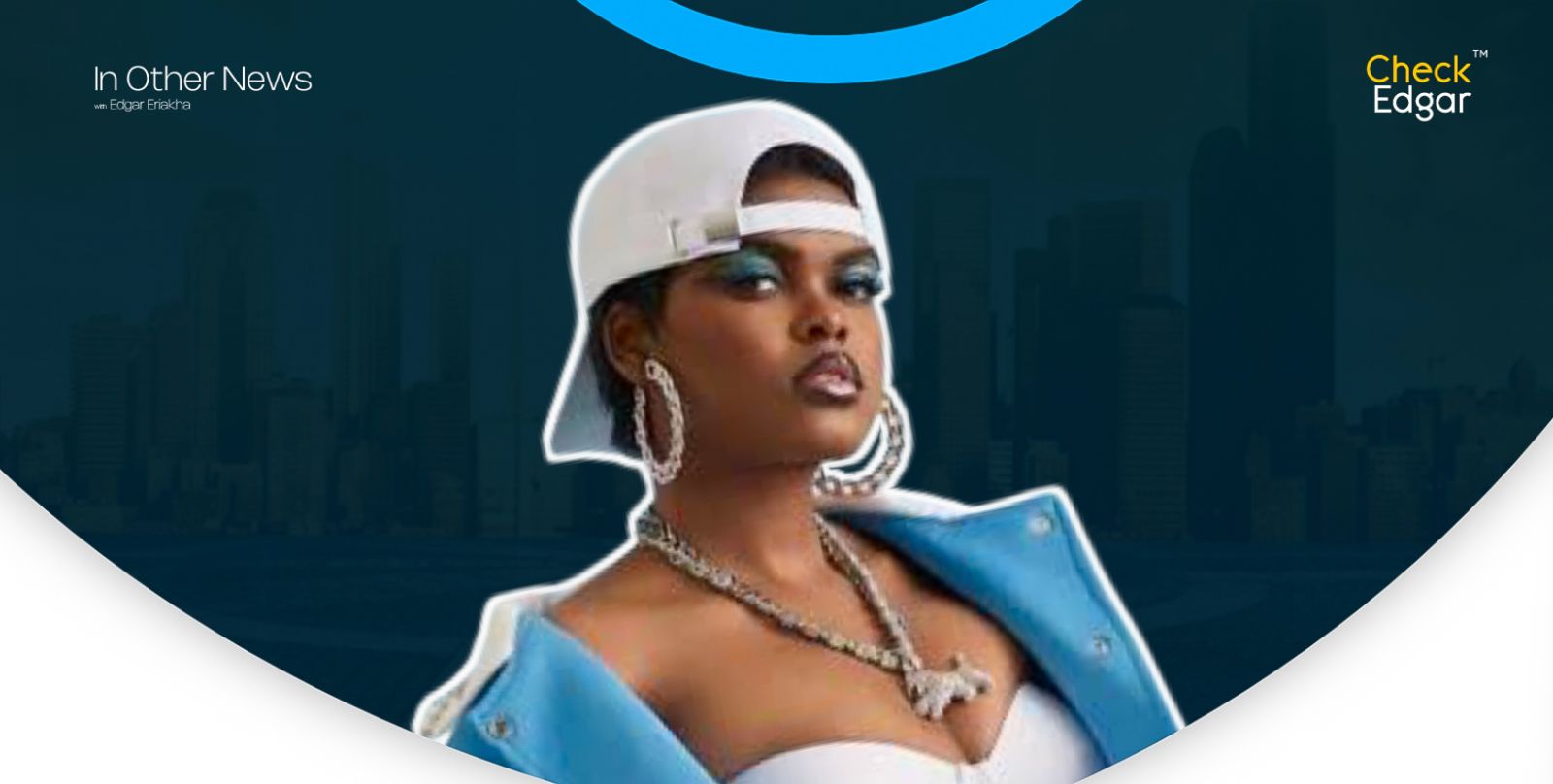 Jarvis with bold makeup wearing a white cap and blue jacket poses confidently.