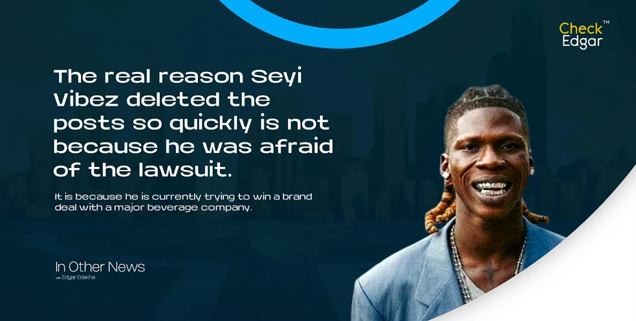 Seyi Vibez with braided hair and a grill smiles while wearing a blue suit.