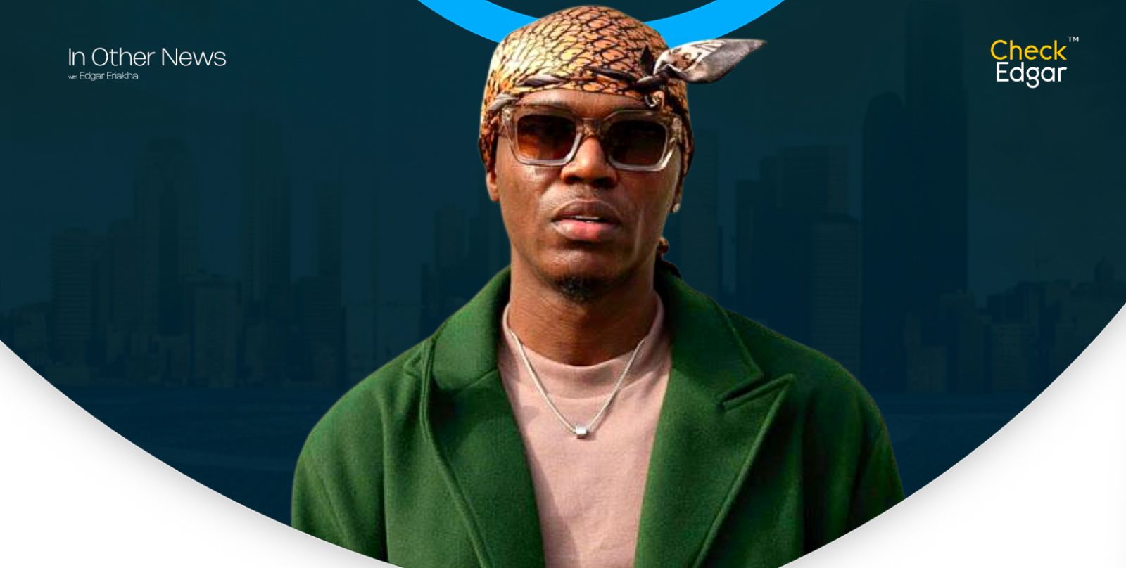 Spyro wearing sunglasses and a patterned headscarf poses in a green jacket.