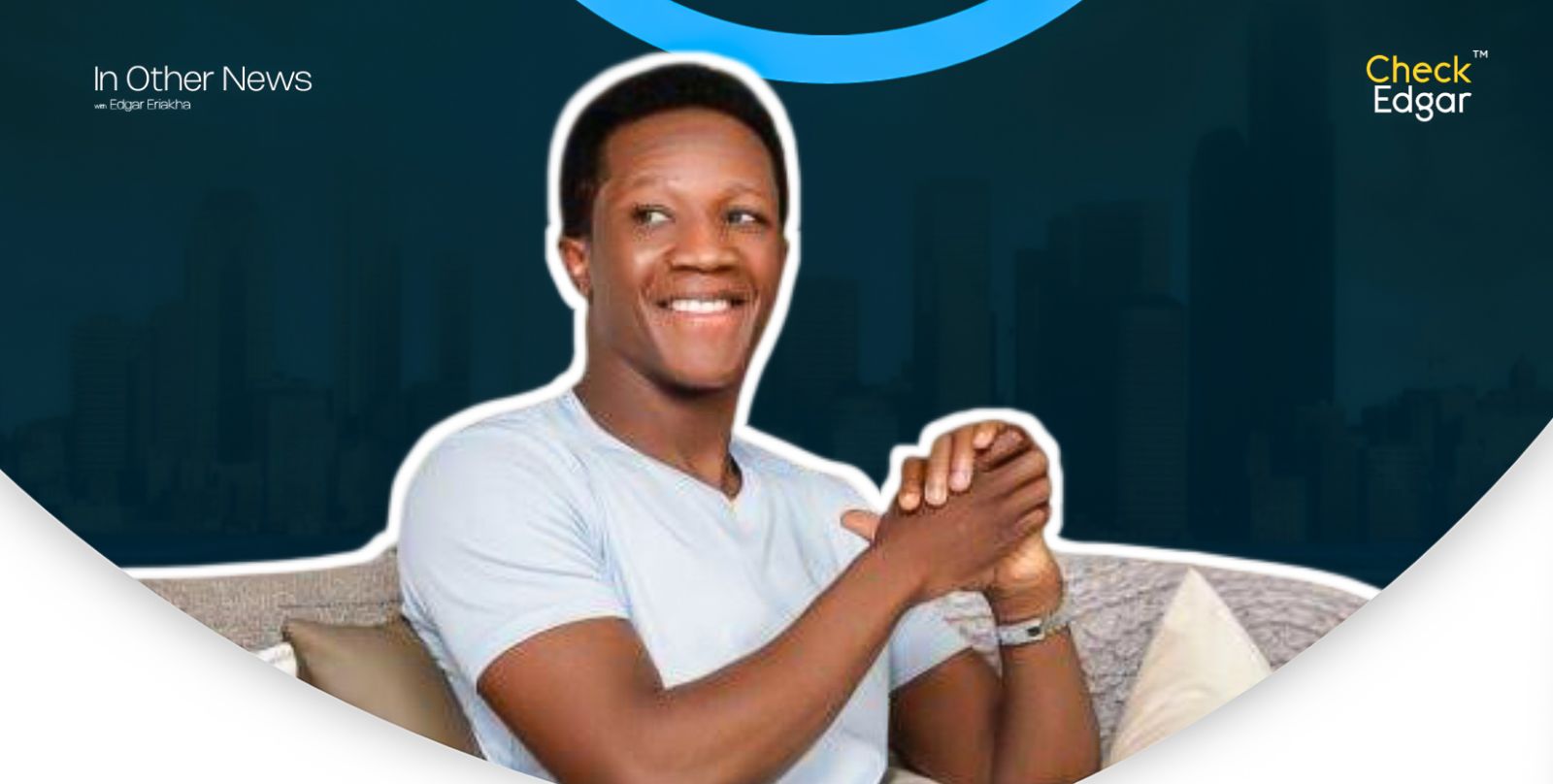 Ahmed XM in white shirt smiles while sitting on a couch.