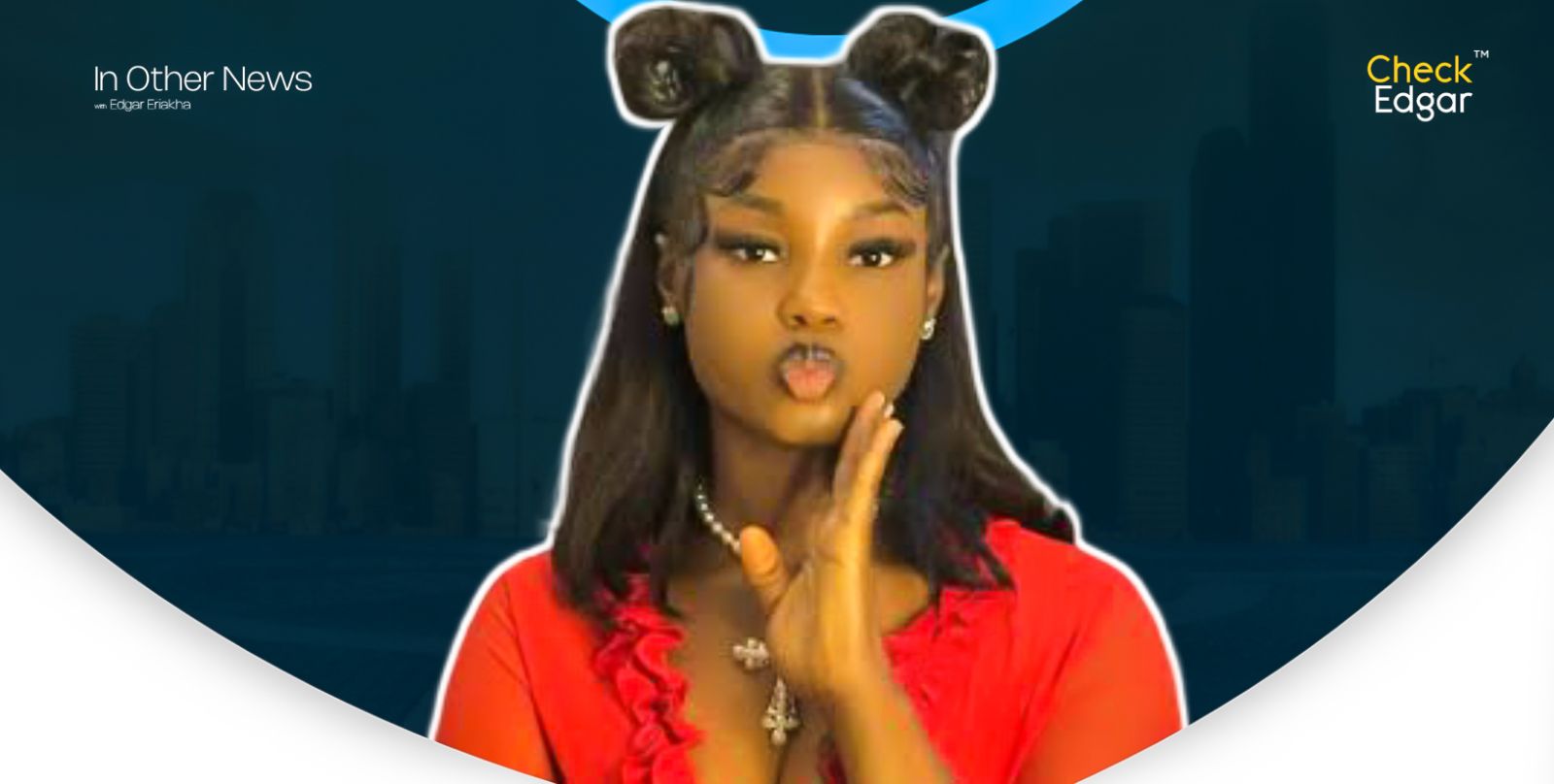 King Mitchy in a red outfit, with her hair in two buns, playfully puckering her lips and gesturing with her hand.