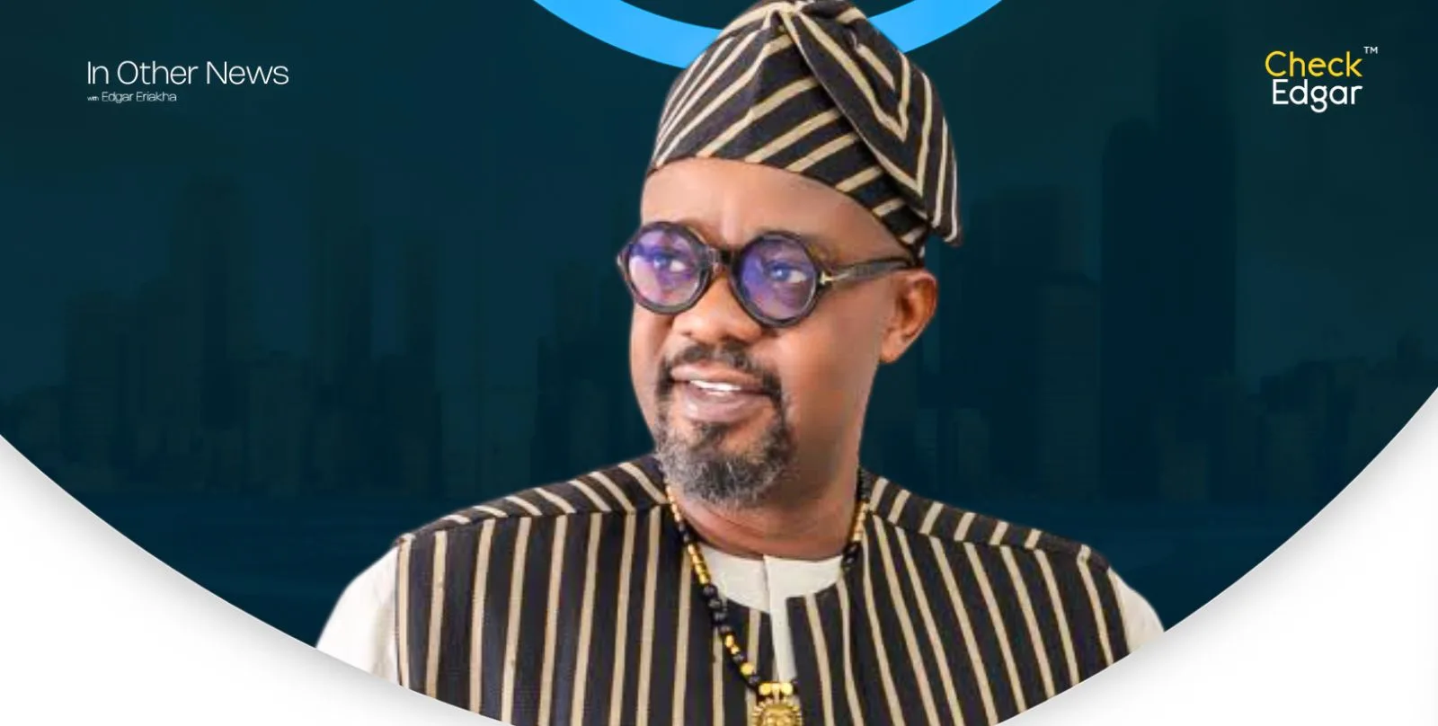 Charles Inojie in traditional attire with striped pattern and glasses.