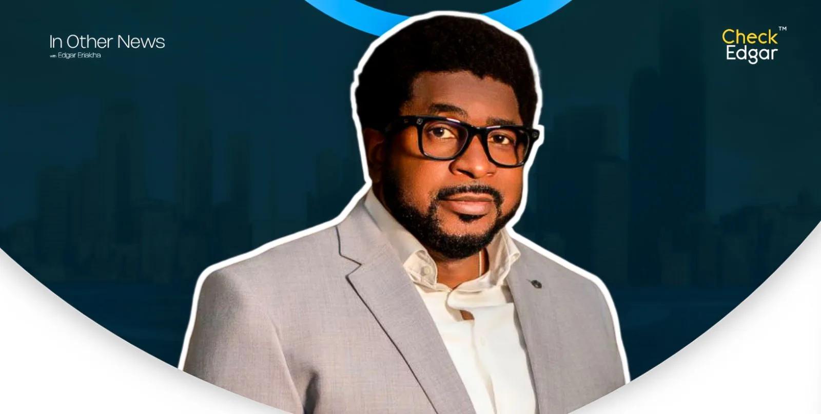 Pastor Kingsley Okonkwo with glasses and curly hair wearing a light grey suit.
