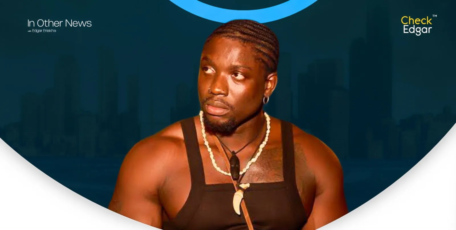 Close-up of a VDM with a serious expression, sporting braids and a necklace.