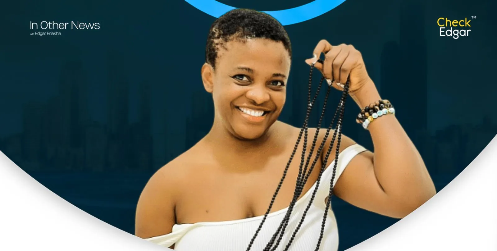 Angela Nwosu holding a string of beads, wearing a white off-shoulder top.