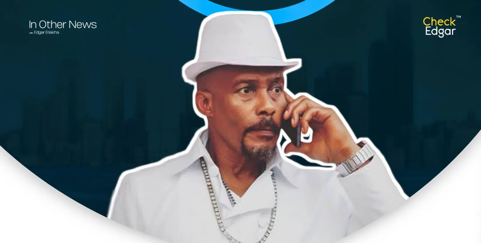 Hanks Anuku in a white outfit and hat talking on the phone.