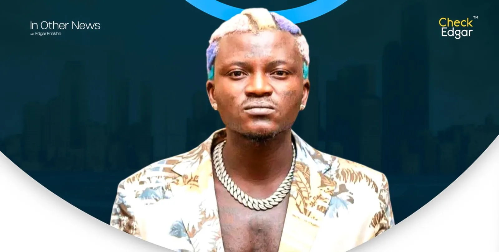Portable wearing a patterned jacket and chain, looking confidently at the camera.