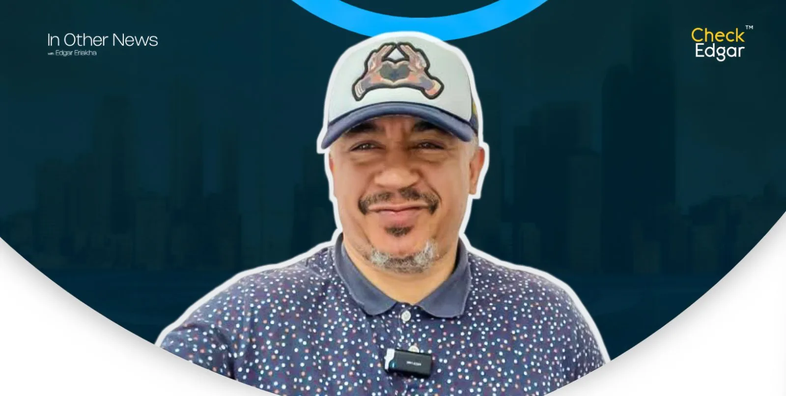 Daddy Freeze in a patterned shirt and cap smiles at the camera.