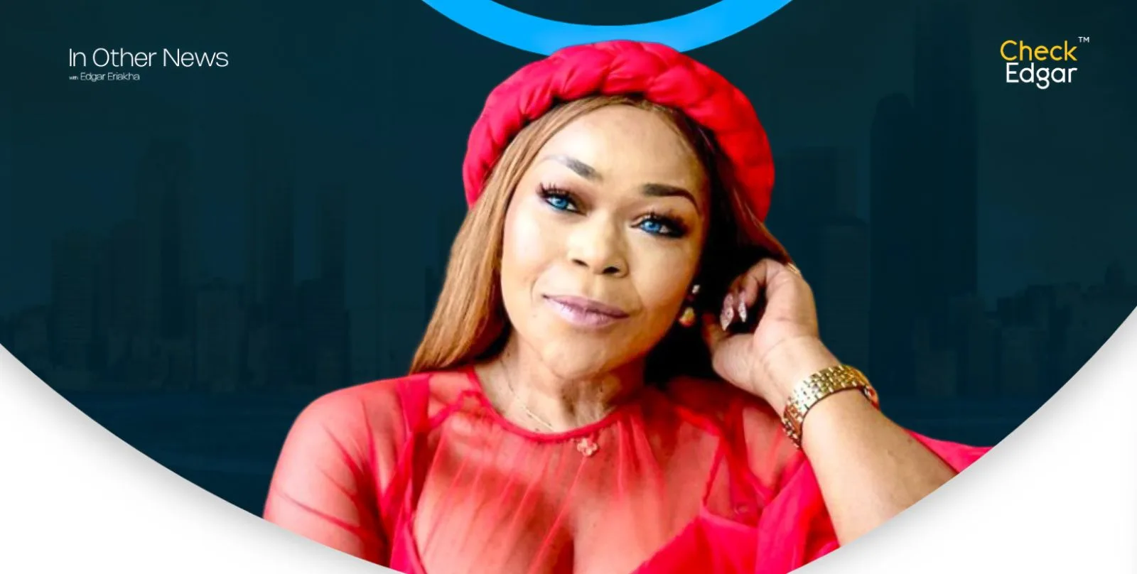 Shaffy Bello with long hair, wearing a red outfit and headband, smiles while resting her chin on her hand.