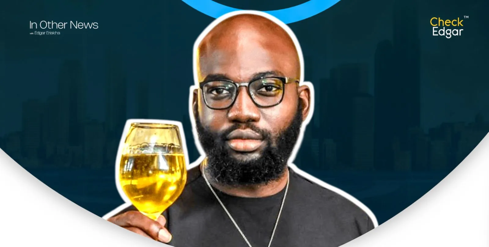 Opeyemi Famakin poses with a drink in hand, wearing glasses and a black shirt.