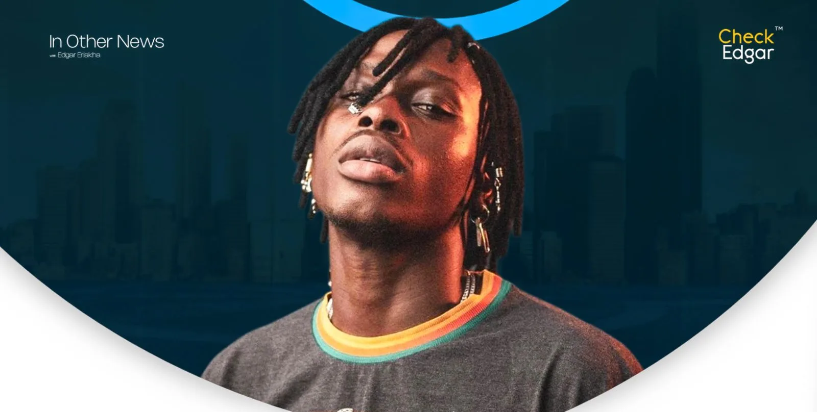 Fireboy DML with dreadlocks poses confidently in a casual grey shirt with a colourful collar.