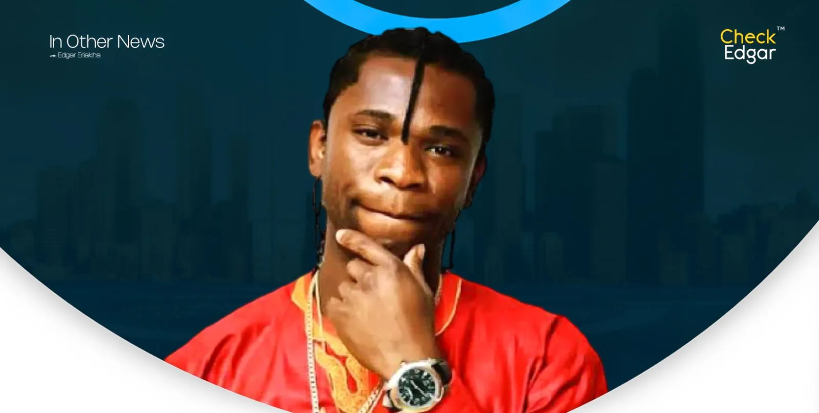 Speed Darlington in a red shirt with a thoughtful expression, holding his chin.