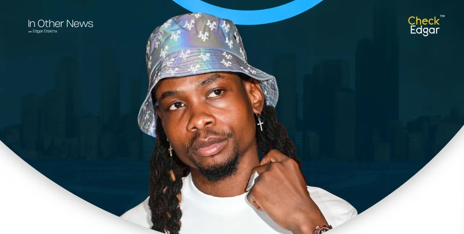Yhemo Lee with dreadlocks wears a shiny bucket hat and white shirt, showing a thoughtful expression.
