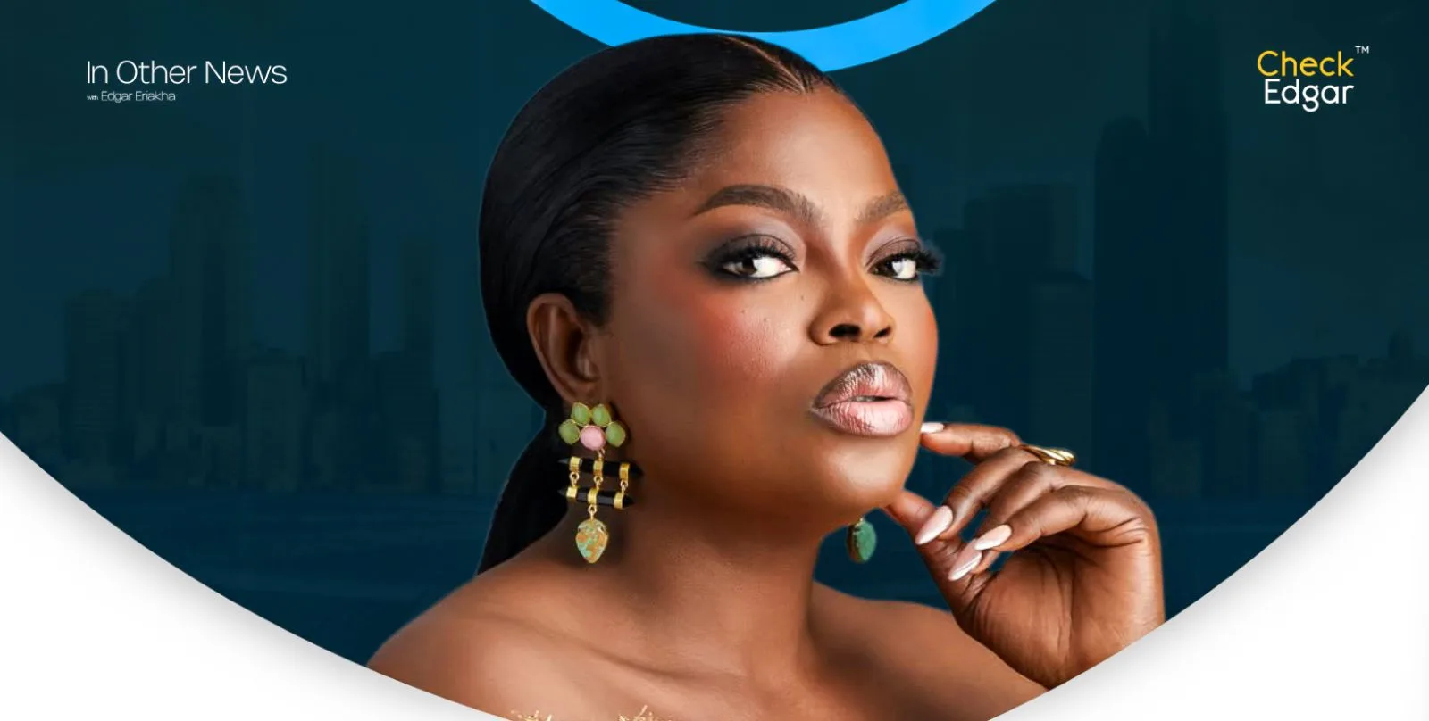 Funke Akindele with long black hair and elegant earrings poses thoughtfully for the camera.